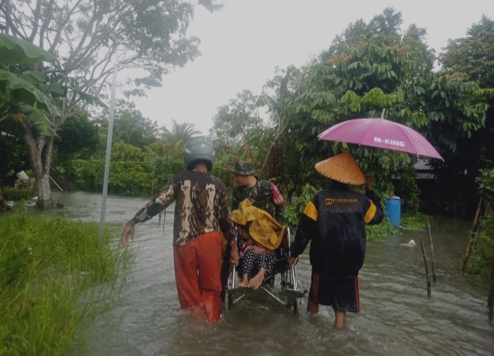 Babinsa Sebong Lagoi Koramil 03/0315 Tanjungpinang Bantu Evakuasi Lansia Terjebak Banjir, Jum'at (03/03/23)./f.dok.Pendim 0315.