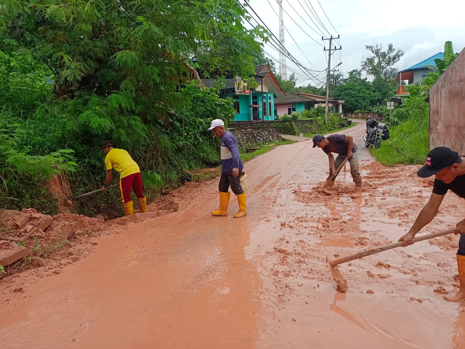 Warga Kelurahan Senggarang Kota Tanjungpinang saat evakuasi akses jalan yang digenangi air bercampur lumpur bauksit, Sabtu (25/05/25)/f.dok.Rat.