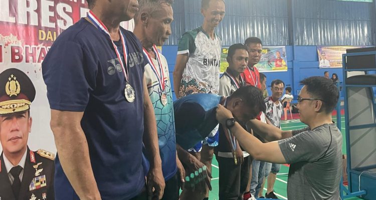 Kapolres Bintan AKBP Riky Iswoyo saat menyerahkan Piagam kepada Pemenang Kejuaraan Turnamen Badminton, Senin (27/05/24) malam/f.dok.Hms.